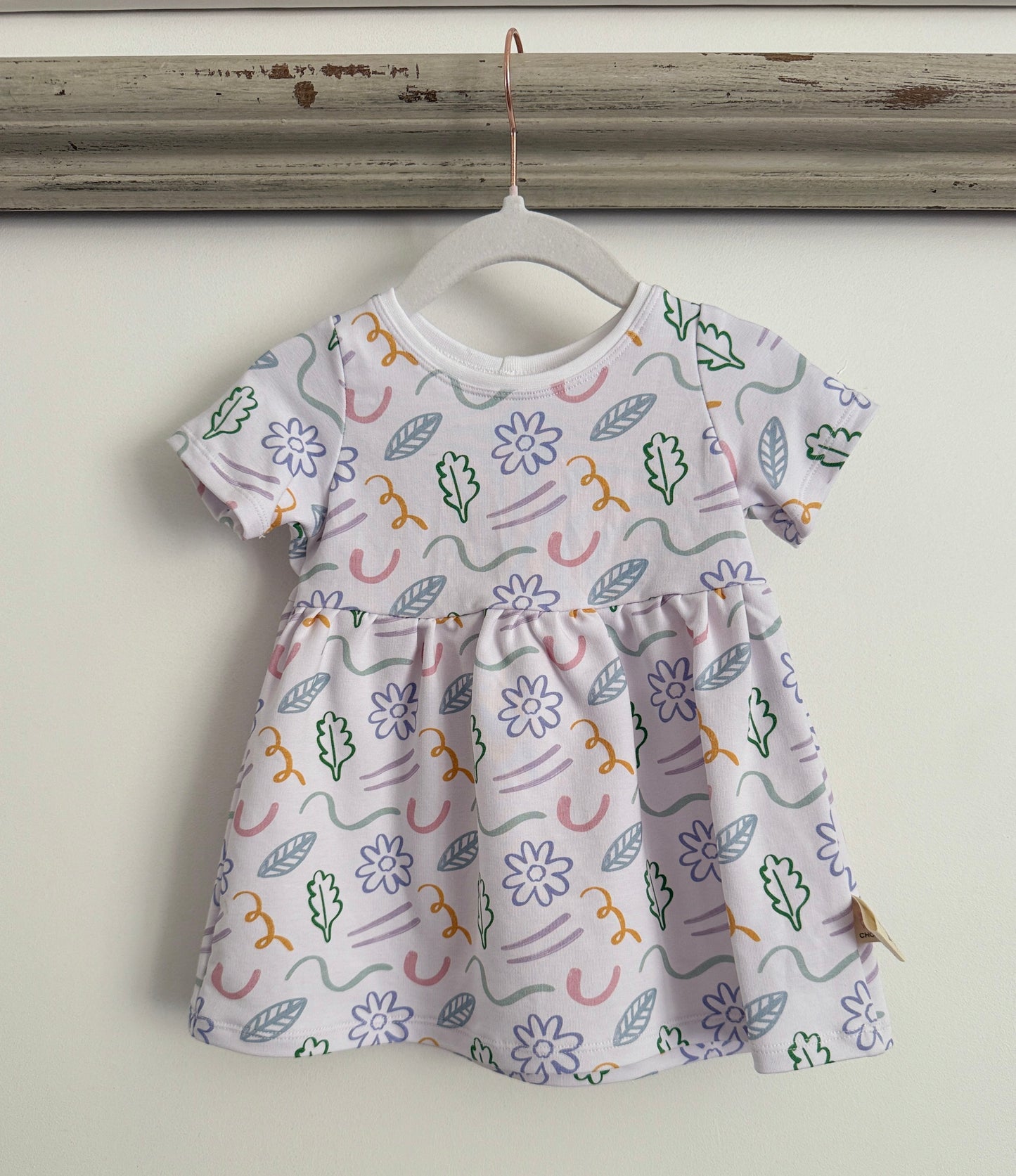 Exclusive floral kids jersey dress handmade of sustainable fabric on a white base with colourful flowers and line detail