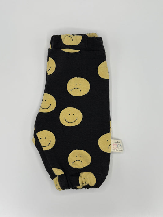 Black unisex sweatpants with yellow happy and sad faces. Elasticated waist and cuffs