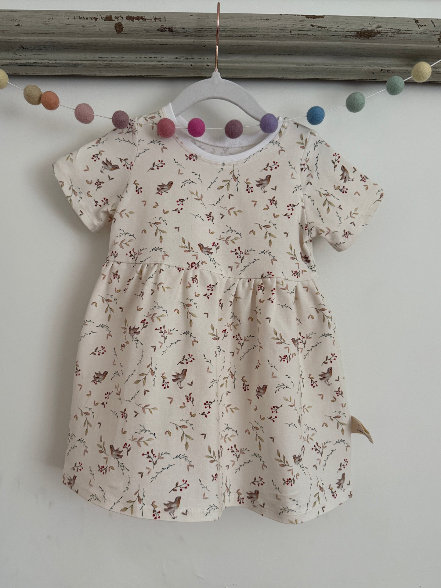Cream kids jersey dress with robin and branch print. Handmade from sustainable fabric